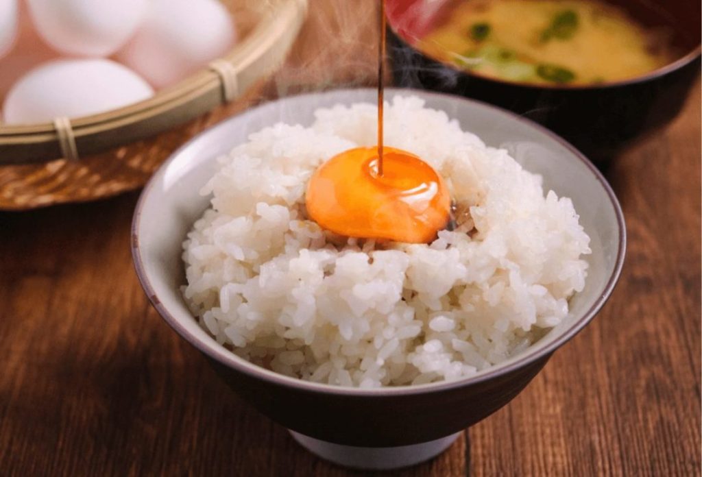 A raw egg on a rice bowl of steamed rice