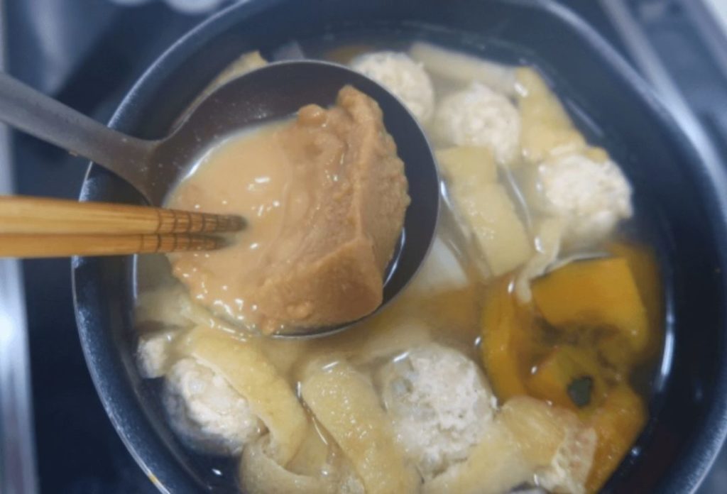 Miso dissolved in dashi (Japanese broth) with chopsticks