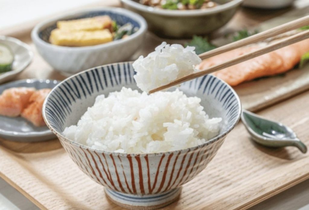 Steaming hot rice picked up with chopsticks